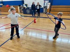 children in gym with hula hoops